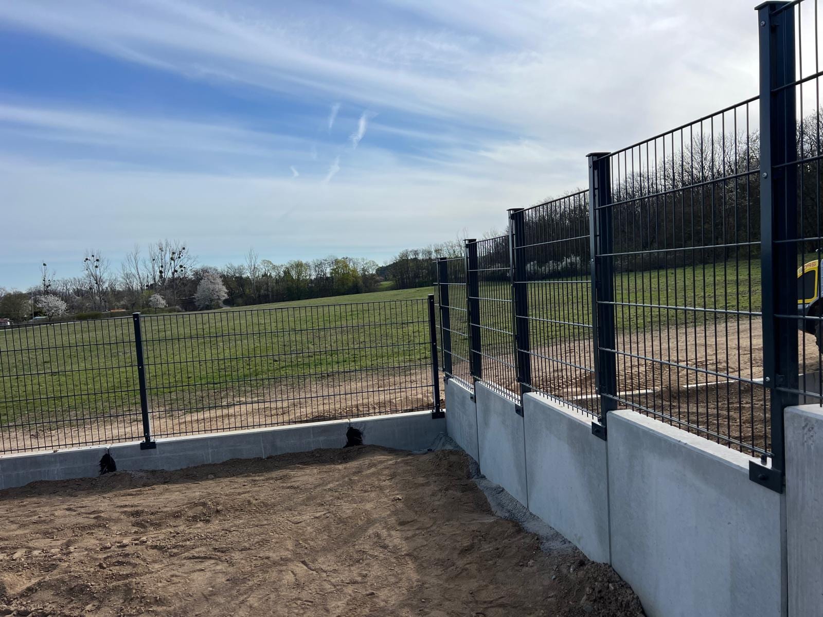 Doppelstabmatte-Zaun auf Betonsockel im offenen Gelände
